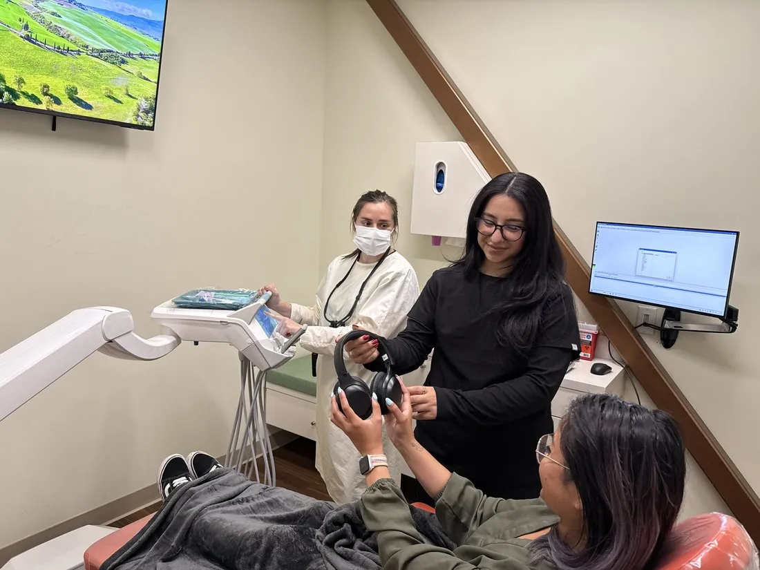 A patient offered noise-cancelling headphones during a relaxed visit at Deccan Dental, San Mateo
